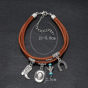 Close-up of leather multi-layer bracelet with luck horseshoe, cactus and boot charms