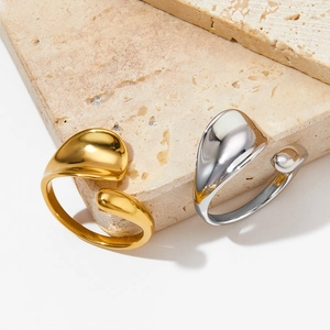 Irregular water drop open rings in gold and silver finish on natural stone background