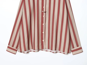 Gros plan du tissu de chemise à rayures rouges et beige avec coutures et boutons