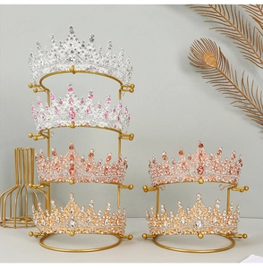 Detailed display of assorted crystal bridal tiaras on a tiered gold metal display stand