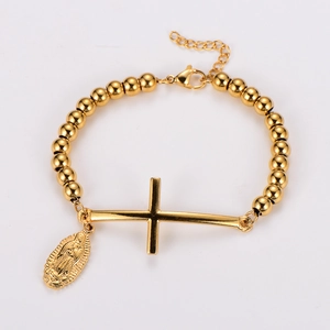 Polished gold beaded bracelet featuring a cross charm and oval Virgin Mary pendant detail