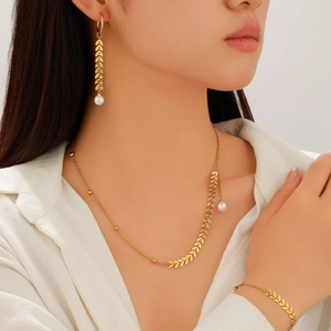 Parure de bijoux dorés avec perles incluant collier, boucles d'oreilles et bracelet