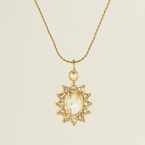 Detailed view of gold necklace with oval crystal pendant surrounded by small zircons