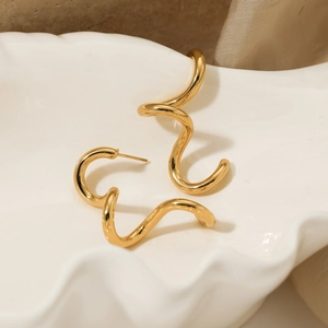 Polished gold spiral curve earrings with a minimalist modern design on a white tray