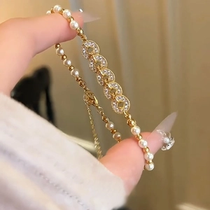 Detailed close-up of a gold pearl bracelet with zircon rings and an adjustable lobster clasp