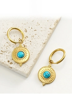 Makro-Detail von 18K vergoldeten Creolen mit sonnenförmigem blauen Türkis-Anhänger