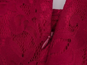 Détail de la fermeture éclair invisible et du motif en dentelle florale sur la robe rouge foncé