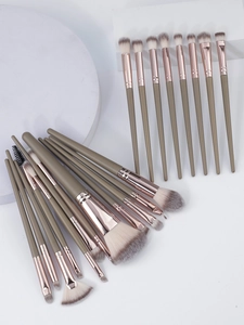 Macro view of 21 professional makeup brushes with rose gold ferrules on white blocks