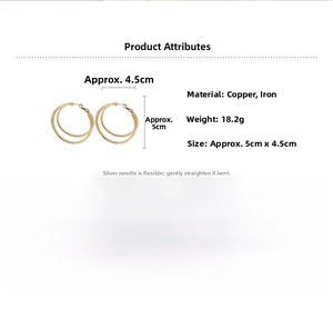 Détail de boucles d'oreilles doubles cercles dorés avec texture gravée et tiges en argent