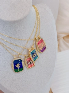 Detail view of four tarot necklaces in vibrant enamel colors with gold and zircon accents