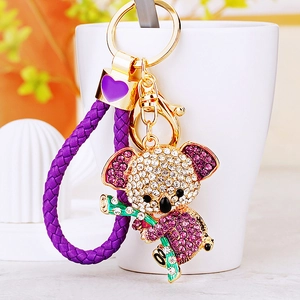 Detailaufnahme eines Kristall-Koala-Schlüsselanhängers mit lila Strass auf einer Tasse