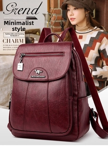 Detail of burgundy faux leather backpack showing litchi texture and metal kangaroo logo