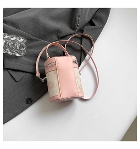 Detailed close-up of pink PU leather and beige jacquard fabric on the stylish cylinder bag