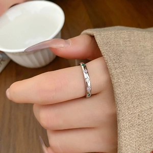 Detailed close-up of a silver star ring set with colorful zircon on a finger