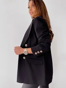 Detail of golden lion embossed buttons on a sleek black double-breasted blazer