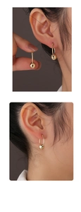 Close-up of minimalist 14K gold plated silver hoop earrings with sliding metal beads