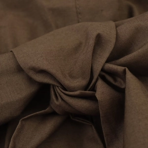 Detailed macro view showing the dark brown poplin fabric texture and weave of the dress