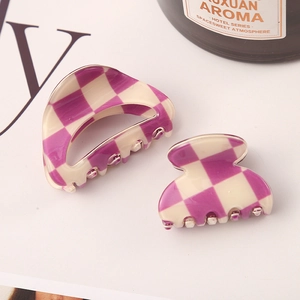 Close-up of purple and cream checkerboard hair claws in two sizes with acetic acid texture