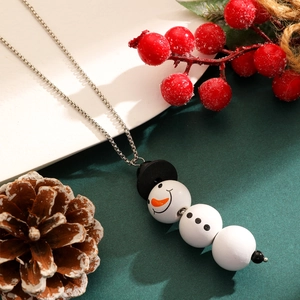 Gros plan du collier de Noël argenté avec un pendentif bonhomme de neige en perles