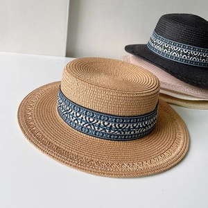 Dettaglio di cappelli di paglia intrecciati con nastri geometrici in vari colori