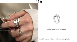 Detail of silver crisscross ring with white rectangular resin and zircon stones
