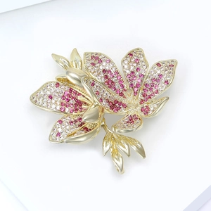 Detail of flower brooch with gold plating and pink, red, and white cubic zirconia