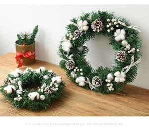 Detail of winter wreaths with cotton, pine cones, and berries in two different sizes