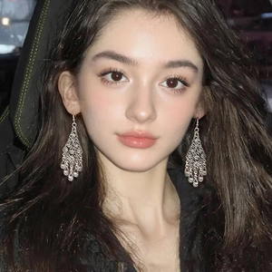 Elegant silver hollow floral drop tassel earrings worn by model in a sophisticated setting