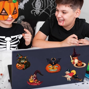 Close-up of Halloween stickers featuring black cat, pumpkin and bat on a laptop