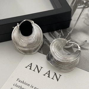 Irregular silver textured hoop earrings with a layered wave design and brushed finish