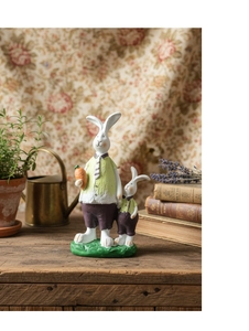 Detail of resin rabbit figurines in garden style on a rustic wooden tabletop