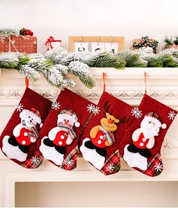 Detail of four linen Christmas stockings with Santa, reindeer, and snowman fireplace decor