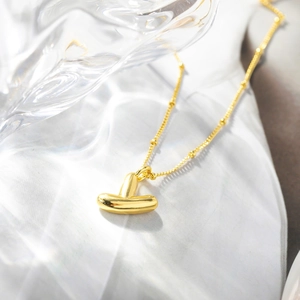 Dettaglio della collana a lettera T a palloncino placcata oro 18K con finitura a specchio