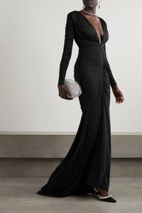 Dettaglio dell'elegante abito nero a maniche lunghe con profondo scollo a V e drappeggio
