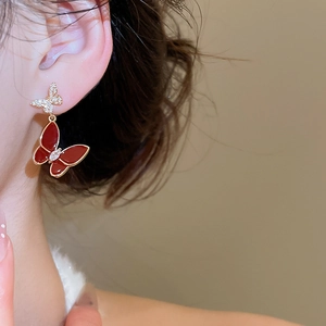 Detail view of red enamel butterfly earrings with gold plating and cubic zirconia accents