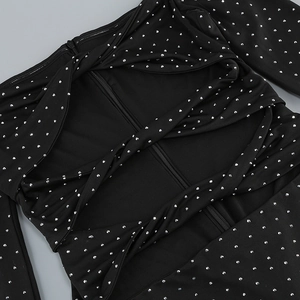 Close-up of black dress with sparkling rhinestones, twisted pleats and zipper detail