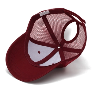 Détail de la casquette rouge avec filet respirant et étiquette de composition en coton