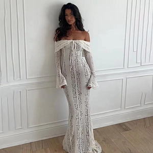 Dettaglio dell'abito in pizzo bianco con spalle scoperte e un elegante fondo a sirena
