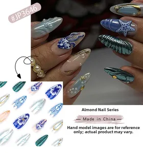 Detail view of almond ocean-themed press-on nails with 3D starfish and shell designs
