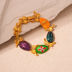 Detail of golden Easter bracelet featuring colorful enamel eggs and bow accents on stone
