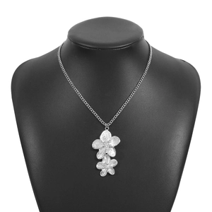 Detail of silver double layered flower pendant on black mannequin with fine chain