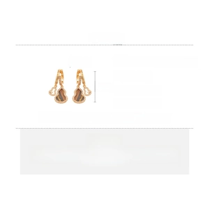 Detail view of gold gourd earrings with copper, zircon, and acetate board measurements