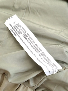 Detail shot of the garment's wash care label showing 100% cotton fabric composition