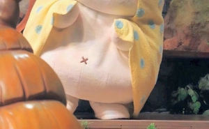 Detailed close-up of white plush fabric texture and yellow blue polka dot accent