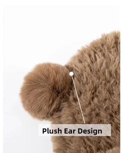 Close-up of the thick brown plush bear ear design on a winter knitted hat