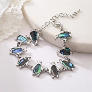 Detailed macro view of penguin charms featuring colorful iridescent abalone shell inlay