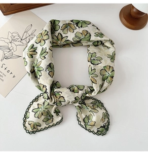 Detail of floral cotton linen neck scarf with dark green lace trim on white background