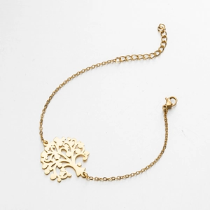Detailaufnahme eines goldenen Lebensbaum-Anhängers an einem minimalistischen Armband