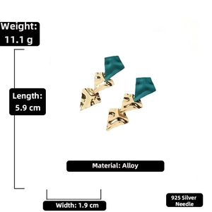 Detailed specs of irregular gold wrinkled metal earrings with dark green matte accent