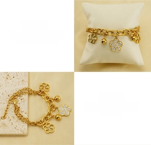 Détail d'un bracelet double chaîne plaqué or 18k avec fleurs évidées et breloques billes